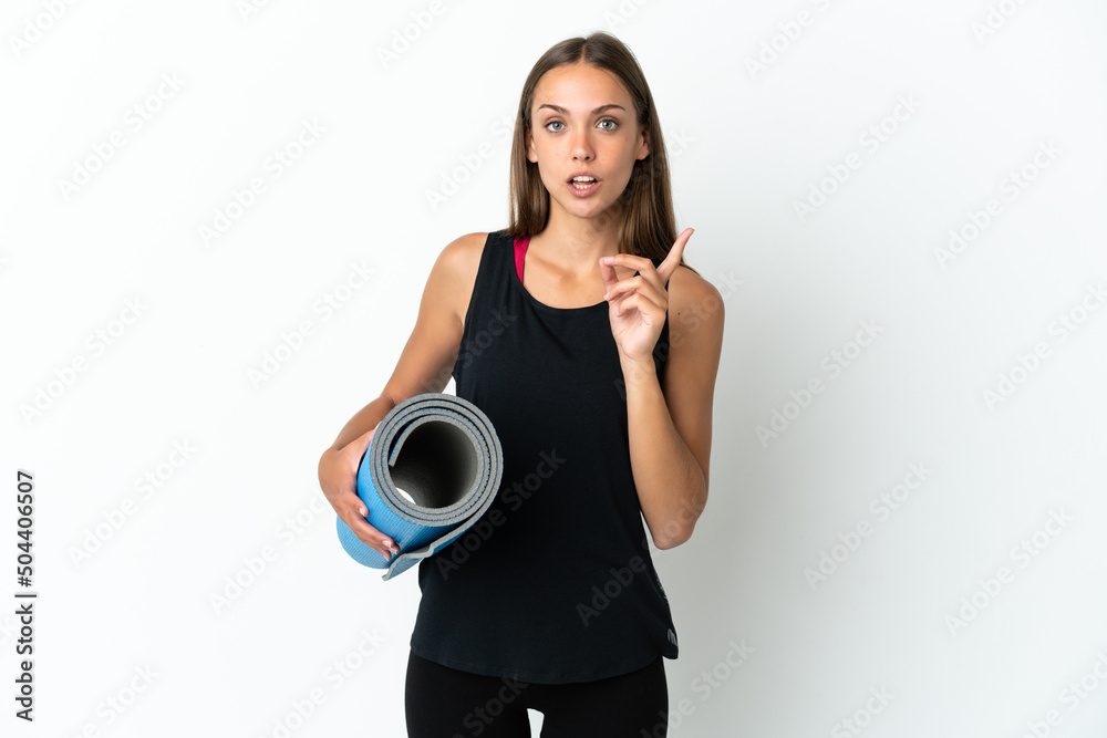 Obraz premium Sport woman going to yoga classes while holding a mat over isolated white background intending to realizes the solution while lifting a finger up