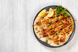 grilled chicken skewers with flatbreads, top view