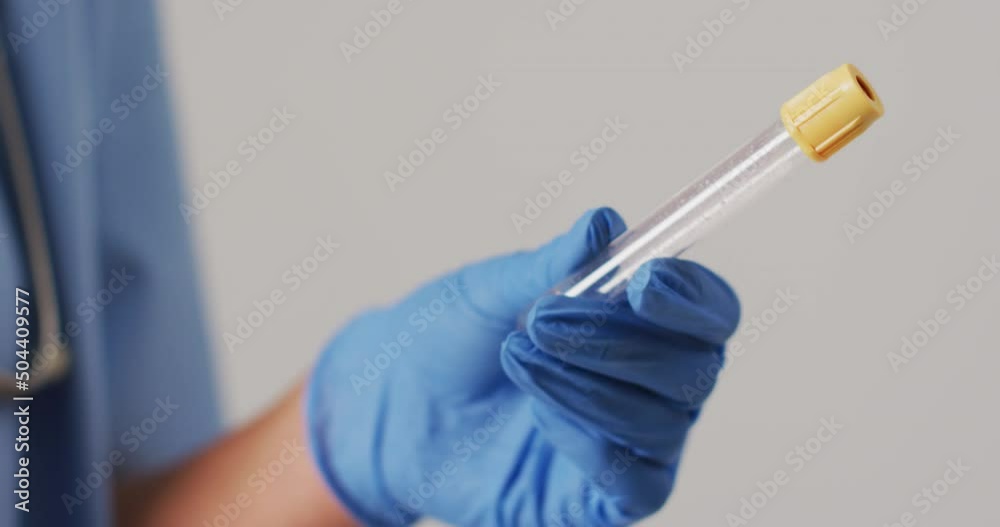 Video of biracial female doctor holding test tube on blue background Video of biracial female doctor holding test tube on blue background