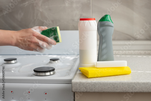 Obraz na plátne cleaning sponge and cleaning products near the stove in the kitchen