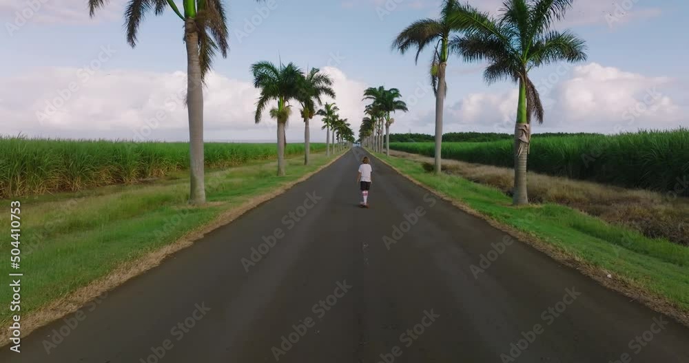 Portrait boy with a longboard on a beautiful road. Teenager skateboarding on city streets