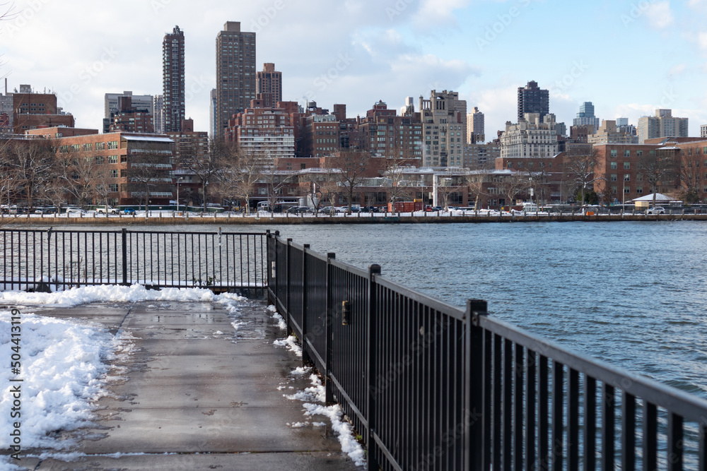 Roosevelt Island and Manhattan Skyline along the East River seen from Astoria Queens New York during the Winter with Snow