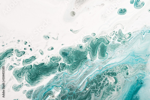 Fluid Art acrylic paints. Abstract mixing blue and green waves on white background. Liquid flows splashes. Marble effect background or texture © colnihko