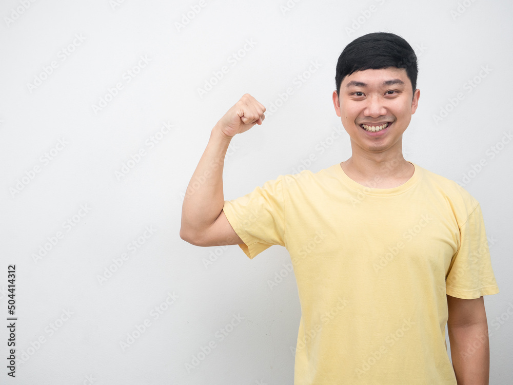 Asian man yellow shirt smiling show muscle copy space Asian man yellow shirt smiling show muscle copy space