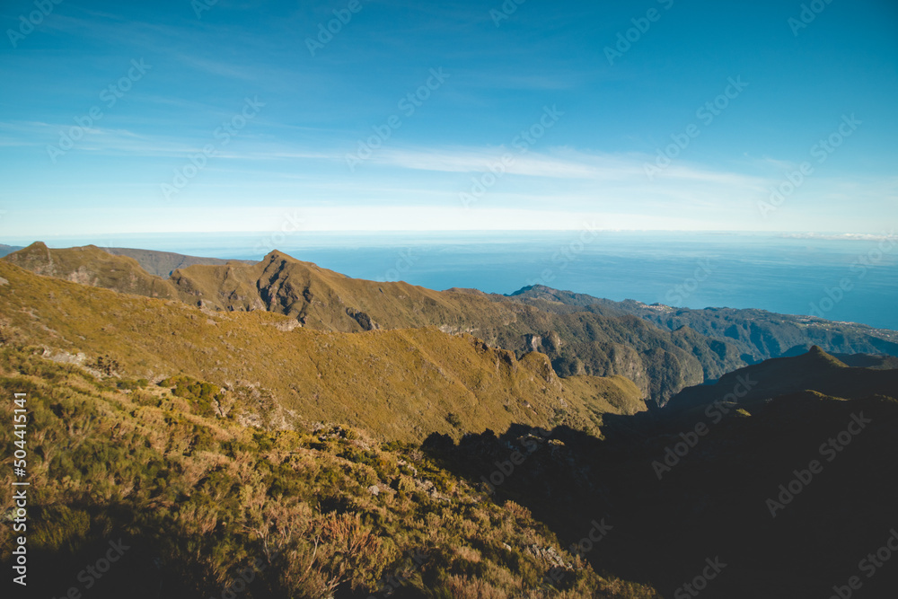 Views of the island of Madeira from the highest mountain, Pico Ruivo. Adventure on a small island in the Atlantic Ocean. Green vegetation turning into a rocky surface. Portugal treasure