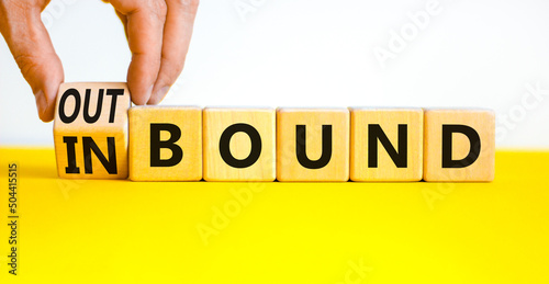 Inbound or outbound symbol. Businessman turns wooden cubes and changes the concept word Outbound to Inbound. Beautiful yellow table white background. Business inbound or outbound concept. Copy space. photo