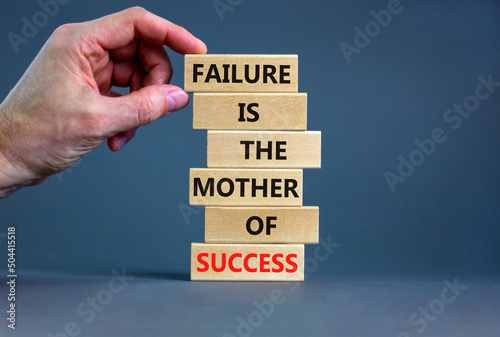 Failure or success symbol. Wooden blocks with words A failure is the mother of success. Beautiful grey table grey background. Businessman hand. Business, failure or success concept. Copy space. photo