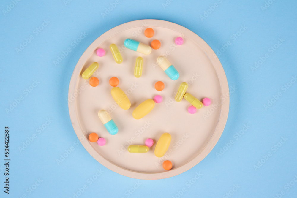 Assorted medicine pills, capsules and tablets on blue background. Immune system vitamins and supplemets. Selective focus Assorted medicine pills, capsules and tablets on blue background. Immune system vitamins and supplemets. Selective focus