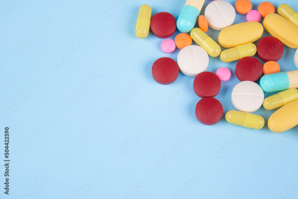 Assorted medicine pills, capsules and tablets on blue background with copy space. Immune system vitamins and supplemets. Selective focus Assorted medicine pills, capsules and tablets on blue background with copy space. Immune system vitamins and supplemets. Selective focus