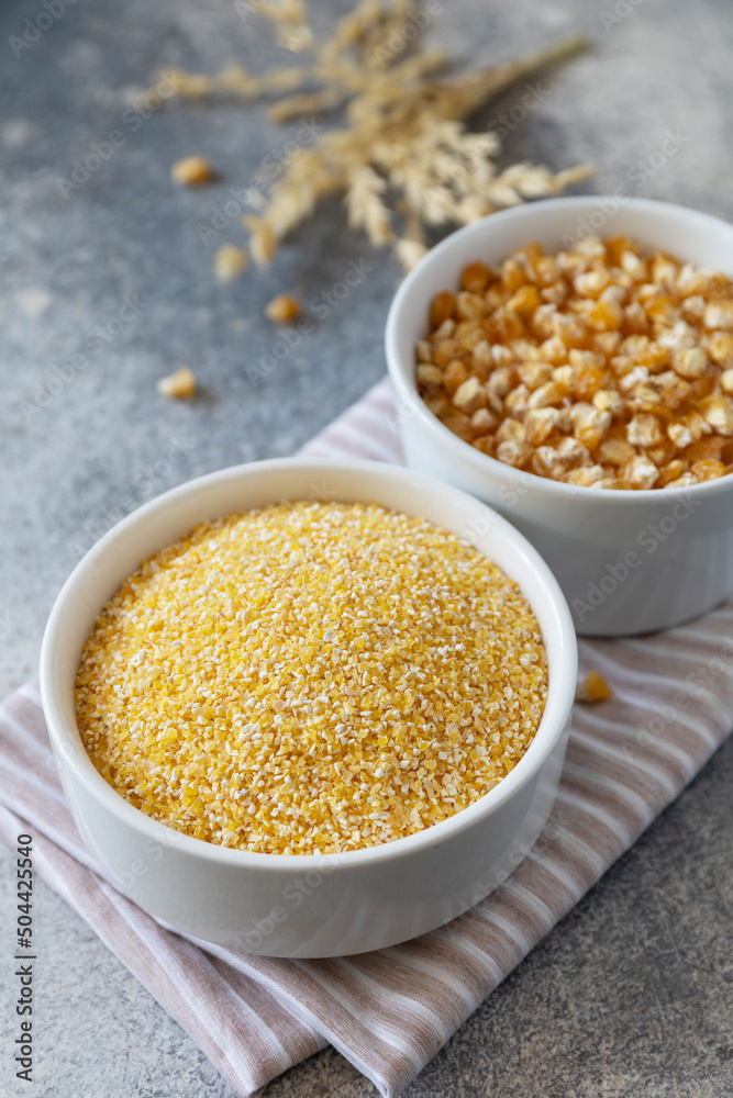 Food and baking gluten-free protein ingredient Сorn flour wholesome and raw corn over gray stone table. Food and baking gluten-free protein ingredient Сorn flour wholesome and raw corn over gray stone table.