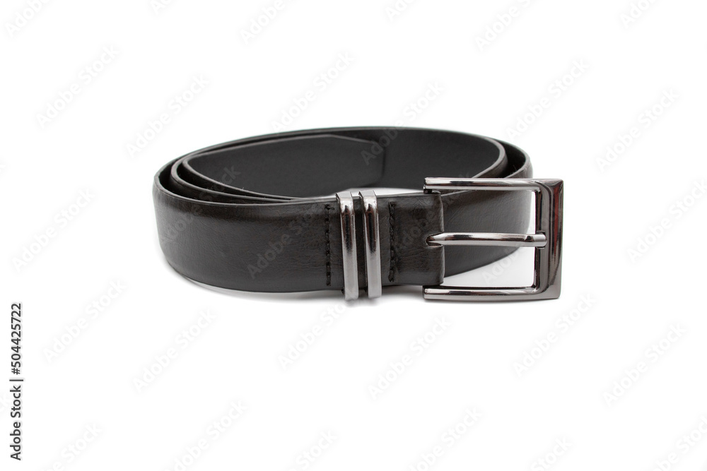 A black belt with a metal buckle, rolled up. Selective focus. Isolated on white background. A black belt with a metal buckle, rolled up. Selective focus. Isolated on white background.