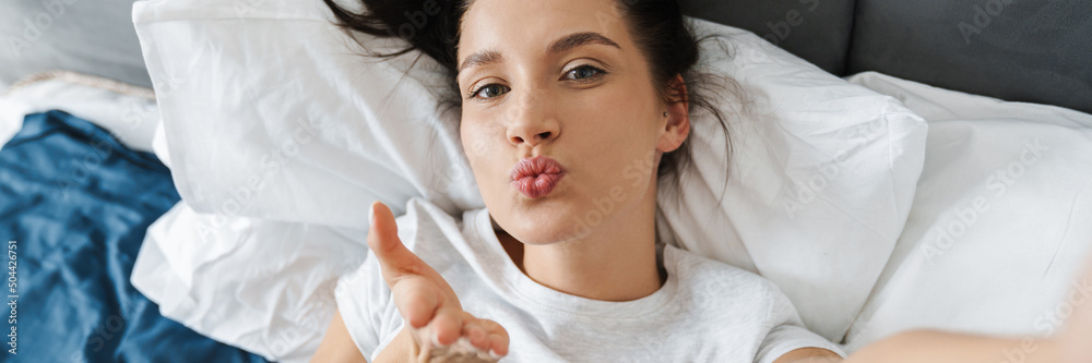 Brunette woman blowing air kiss and taking selfie photo Brunette woman blowing air kiss and taking selfie photo