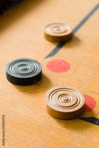 A game of carrom with scattered stones at a corner of the board