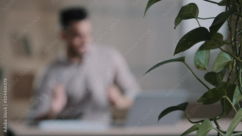 Young happy arabian male student business man drummer having fun at home workplace pretend playing drums dancing movement celebrate career advancement enjoying favourite music blurred defocused view 