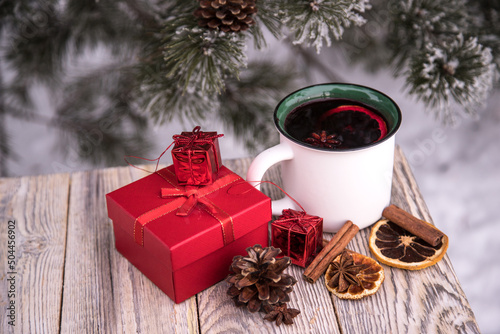 Boxes with gifts next to a warming cup of mulled wine on a winter background.