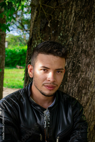 model in a natural environment supported by a tree