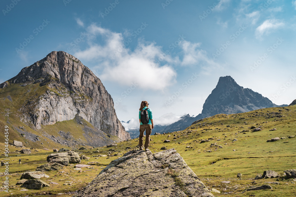 Young Woman With A Backpack on The Top Of a rock in a Beautiful wild Landscape. Discovery Travel Destination Concept