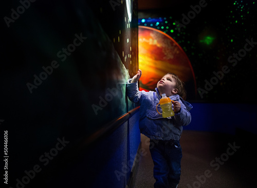 little boy points at paintings of universe photo