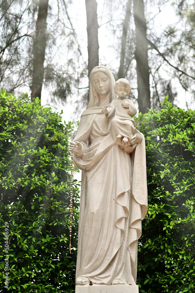 Statue of Our lady virgin Mary with Child Jesus located in front of the catholic church with natural background, Thailand. selective focus.