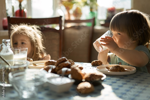Kids eating healthy goodies at sun-drenched room photo