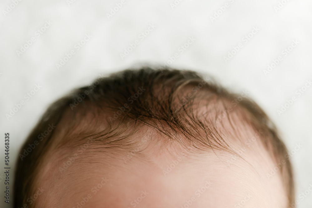 A baby's dark hair and forehead