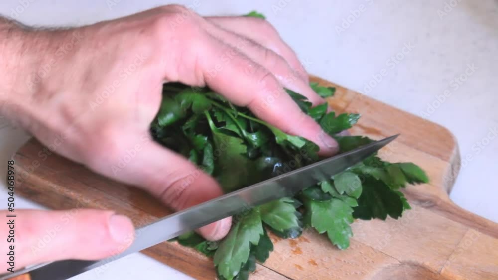 Chopping parsley heap by knife, aromatic vitamins condiment Chopping parsley heap by knife, aromatic vitamins condiment