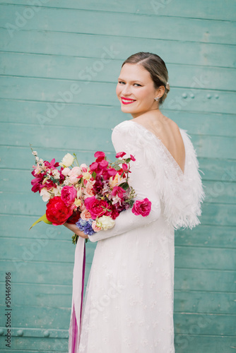 Women in a wedding dress holding vibrant flowers  photo