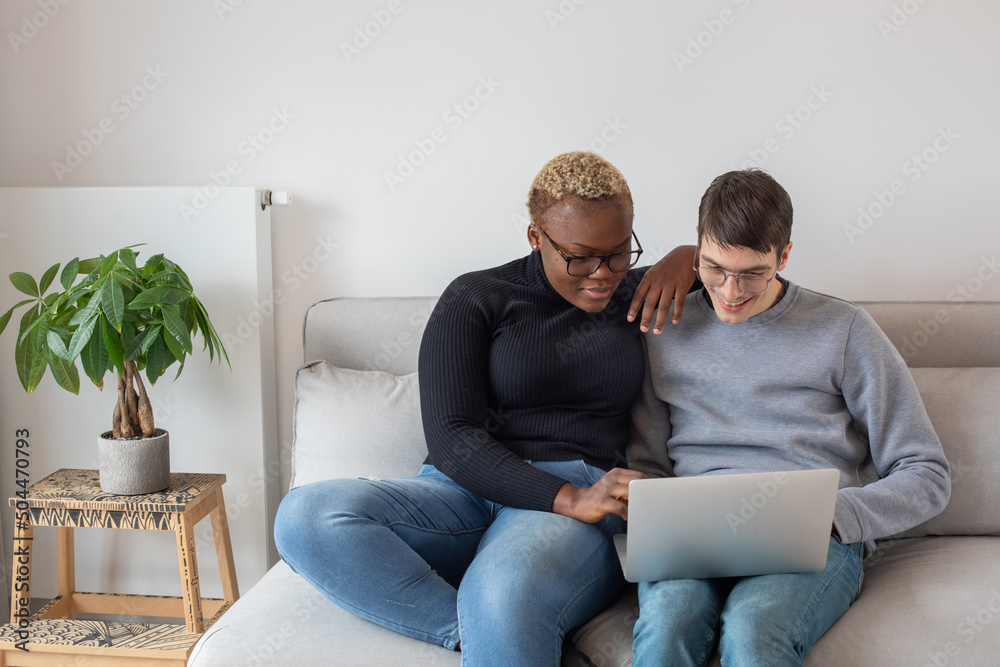 video call, mixed couple using laptop computer at home on couch video call, mixed couple using laptop computer at home on couch