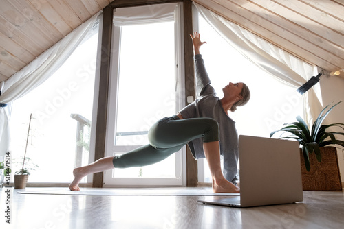 Woman doing Utthita Parivritta Anjaneyasana pose photo