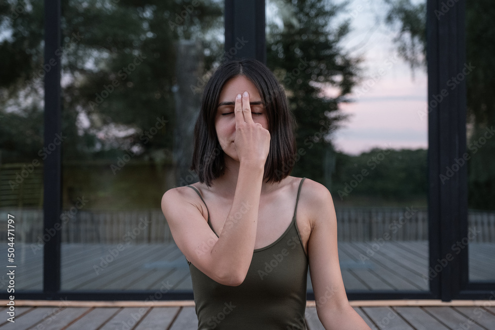 Woman touching Third Eye Chakra during meditation Woman touching Third Eye Chakra during meditation