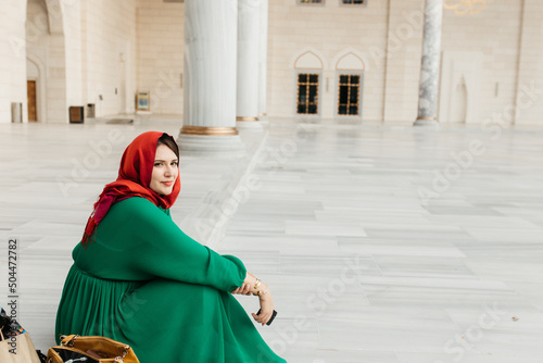 hijabi woman sitting in a mosque yard.  photo