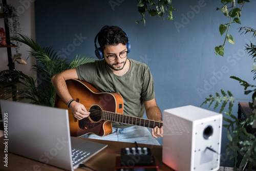 Young Musician Playing Classic Guitar And Composing New Music
