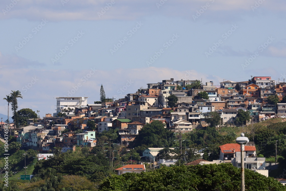 Вид на материковую часть, города Флорианополис, штат Санта Катарина Бразилия, небольшие дома, синее небо, горы на горизонте, океан