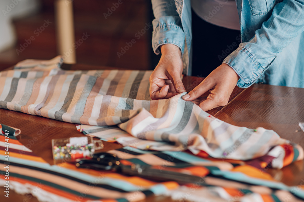 Woman tailor hands working from home and tailoring beautiful clothes