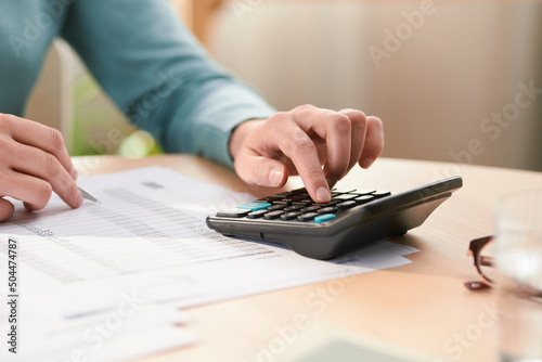 Crop person managing personal money at home photo