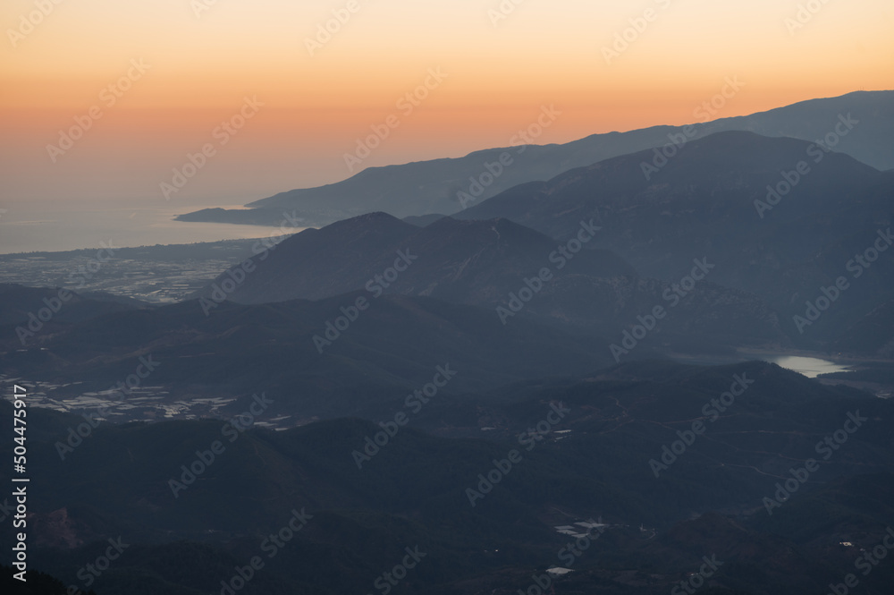 Foggy mountains under sunset sky Foggy mountains under sunset sky