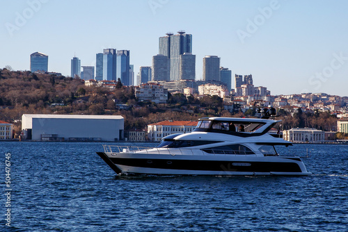 Luxury yacht in a modern city harbor. Istanbul cityscape with skyscrapers in the background. © 9parusnikov
