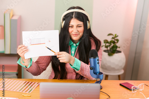 Girly woman teaching online finance course in office photo