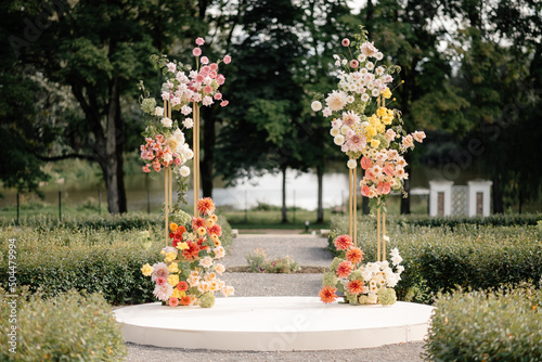 podium with flower installation in wedding arch shape photo