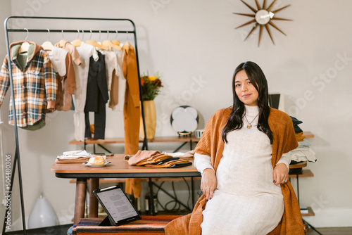 Portrait of pregnant tailor in atelier
