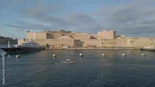 Sailing past Vittoriosa waterfront with boats moored in the waterway photo