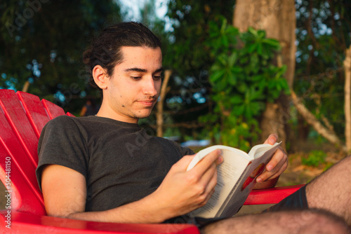 Young man reading a book outdoors. photo