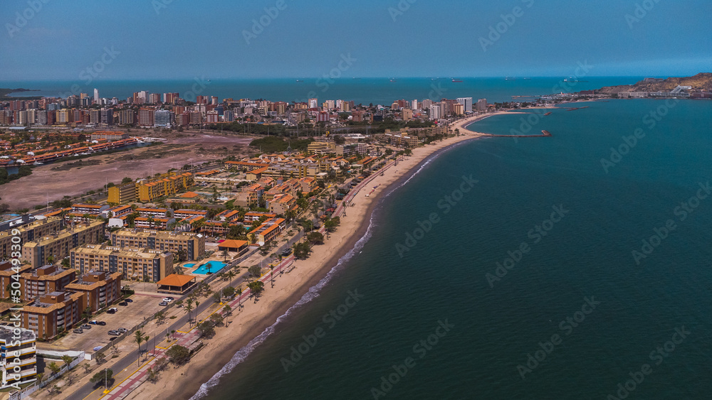 Photos from an aerial view of a drone, of a beach on a cloudy day from different angles and places, the tone of the photos is warm, in the photos you can see vegetation, trees, bushes, grass, sand, sk