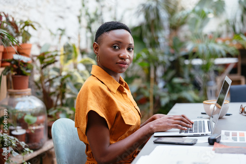 Black employee browsing netbook in workplace photo
