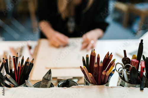 Drawing supplies on table near artist
