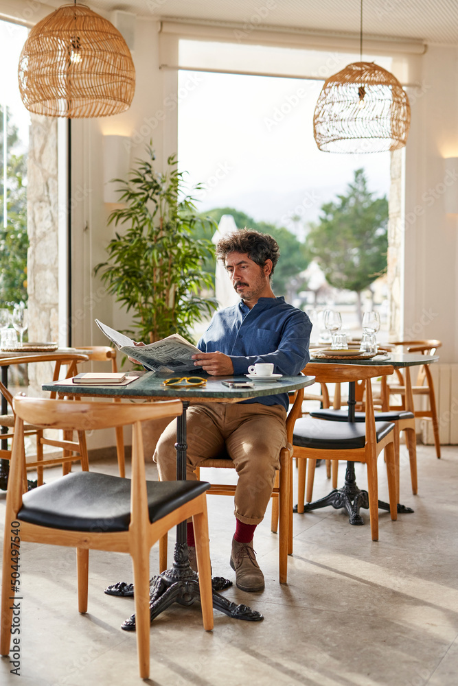 Businessman reading newspaper in restaurant Businessman reading newspaper in restaurant