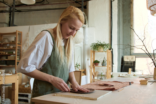 Woman doing handmade ceramics at pottery studio photo