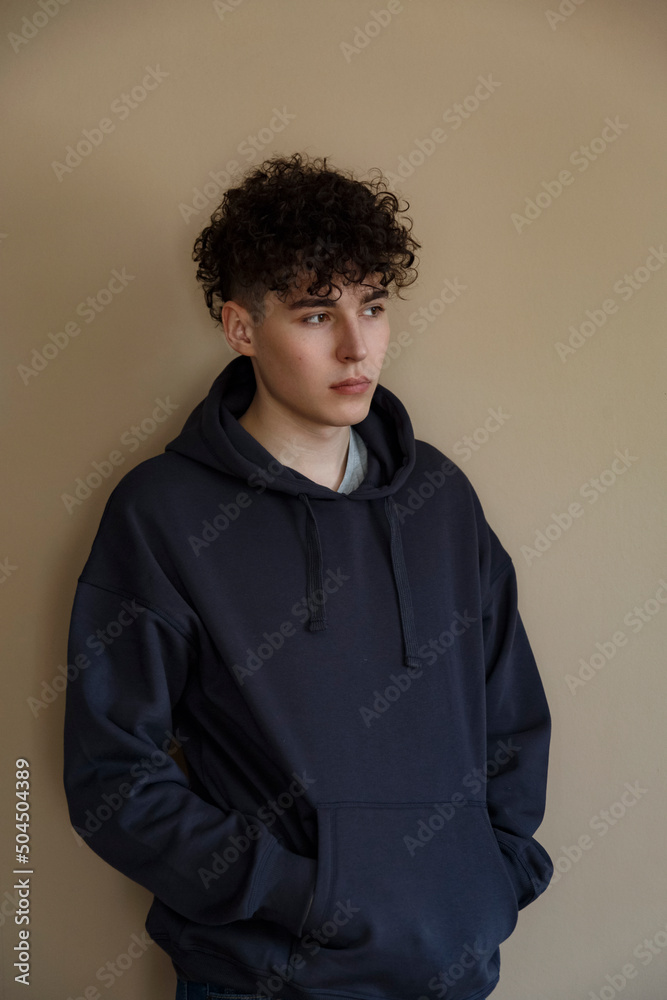 Calm guy standing near wall and looking away Calm guy standing near wall and looking away