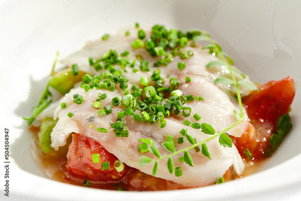 Healthy dinner - fish fillet with tomato and avocado on white plate. Diet food - cooked seabass on vegetables garnish. Keto diet in restaurant menu. Fish menu - cod, snapper, whitefish, catfish. Healthy dinner - fish fillet with tomato and avocado on white plate. Diet food - cooked seabass on vegetables garnish. Keto diet in restaurant menu. Fish menu - cod, snapper, whitefish, catfish.