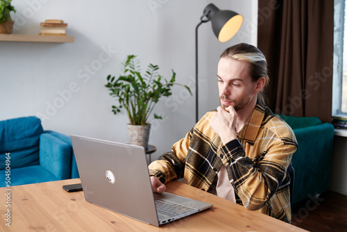 Student typing on laptop at home photo